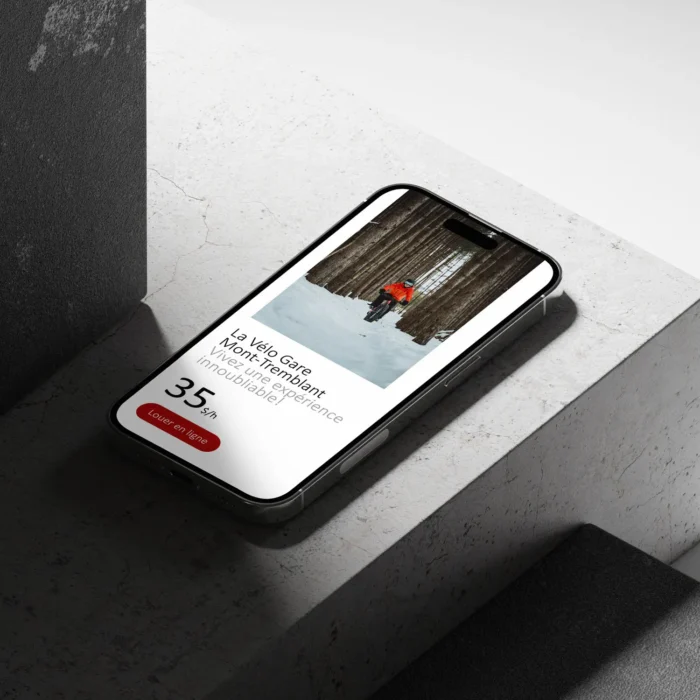 Image du site de Tremblant Booking sur iPhone 14 Pro déposé sur une dalle de ciment